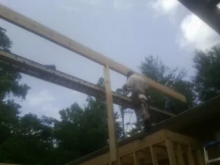 Carpenter setting a ridge beam over a new addition frame — Ice Dam Removal by Roofing Brothers in Coeymans Hollow